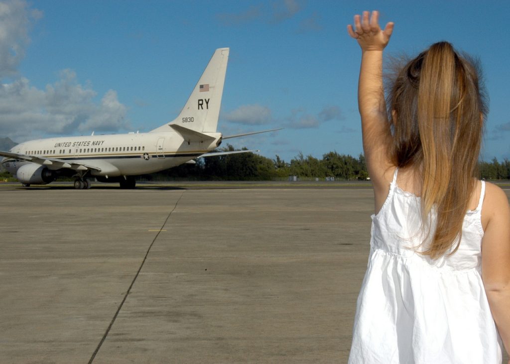 toddler waving at the airplane
