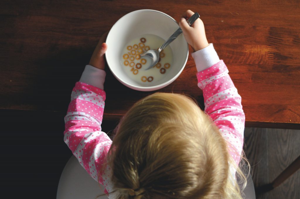 toddler girl eating musli for breakfast
